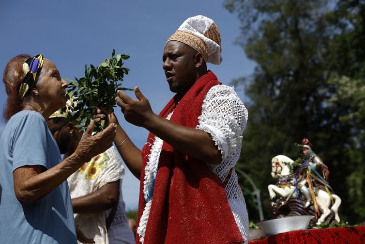 Fernando Frazão/Agência Brasil Rio de Janeiro (RJ), 23/04/2025 – O babalorixá Luiz Alberto de Oxóssi, do candomblé, oferta bençãos a devotos durante as celebrações ao Dia de São Jorge, no centro da cidade. Foto: Fernando Frazão/Agência Brasil