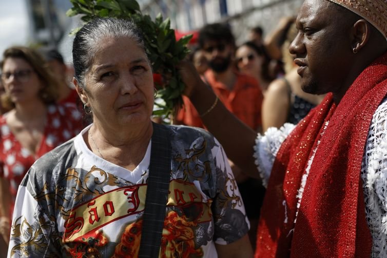 Fernando Frazão/Agência Brasil Rio de Janeiro (RJ), 23/04/2025 – Maria Rosa recebe benção do babalorixá Luiz Alberto de Oxóssi, do candomblé, durante as celebrações ao Dia de São Jorge, no centro da cidade. Foto: Fernando Frazão/Agência Brasil