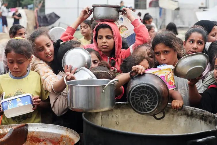 Ramadan Abed Palestinos aguardam para receber comida preparada por uma cozinha comunitária, em Nuseirat, Faixa de Gaza
08/04/2025
REUTERS/Ramadan Abed