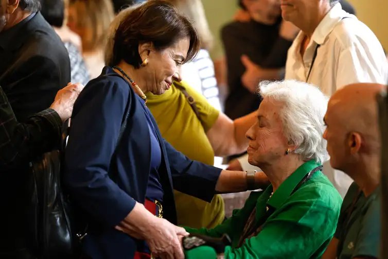 Rio de Janeiro (RJ), 23/07/2026 - Lucy Barreto, esposa de  Barretão, recebe o cumprimento de amigos no velório do cineasta Luiz Carlos Barreto, o Barretão, no Palácio da Cidade, em Botafogo, zona sul da cidade. Foto: Tânia Rêgo/Agência Brasil