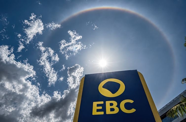25/08/2026 - Brasília - Um halo de 22° circunda o Sol no céu de Brasília. O fenômeno óptico é formado pela refração da luz solar em cristais de gelo presentes em nuvens de grande altitude, criando um enorme anel luminoso ao redor do Sol. Foto: Rafa Neddermeyer/ Agência Brasil